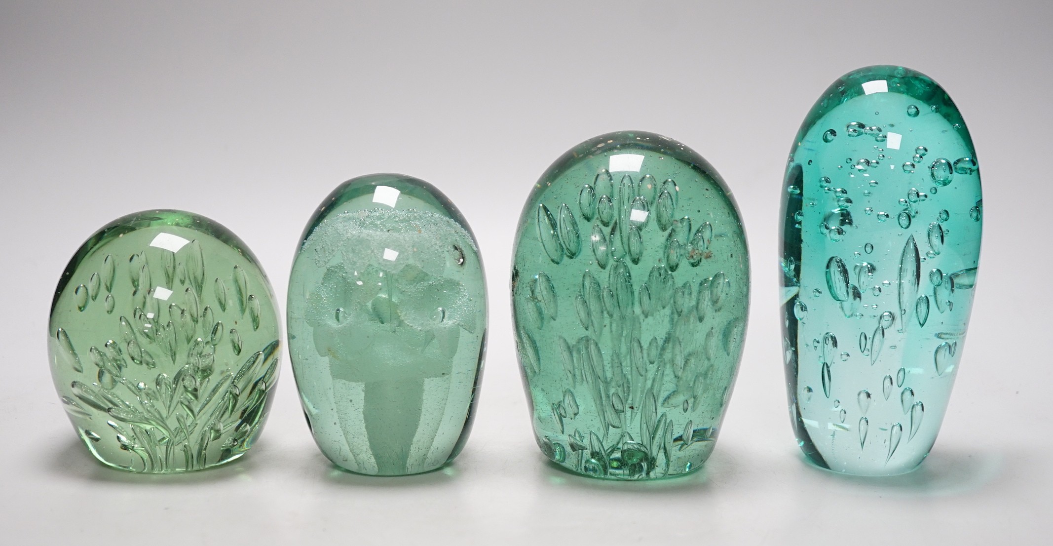 Four 19th century green glass dumps, one floral, tallest 16cms high